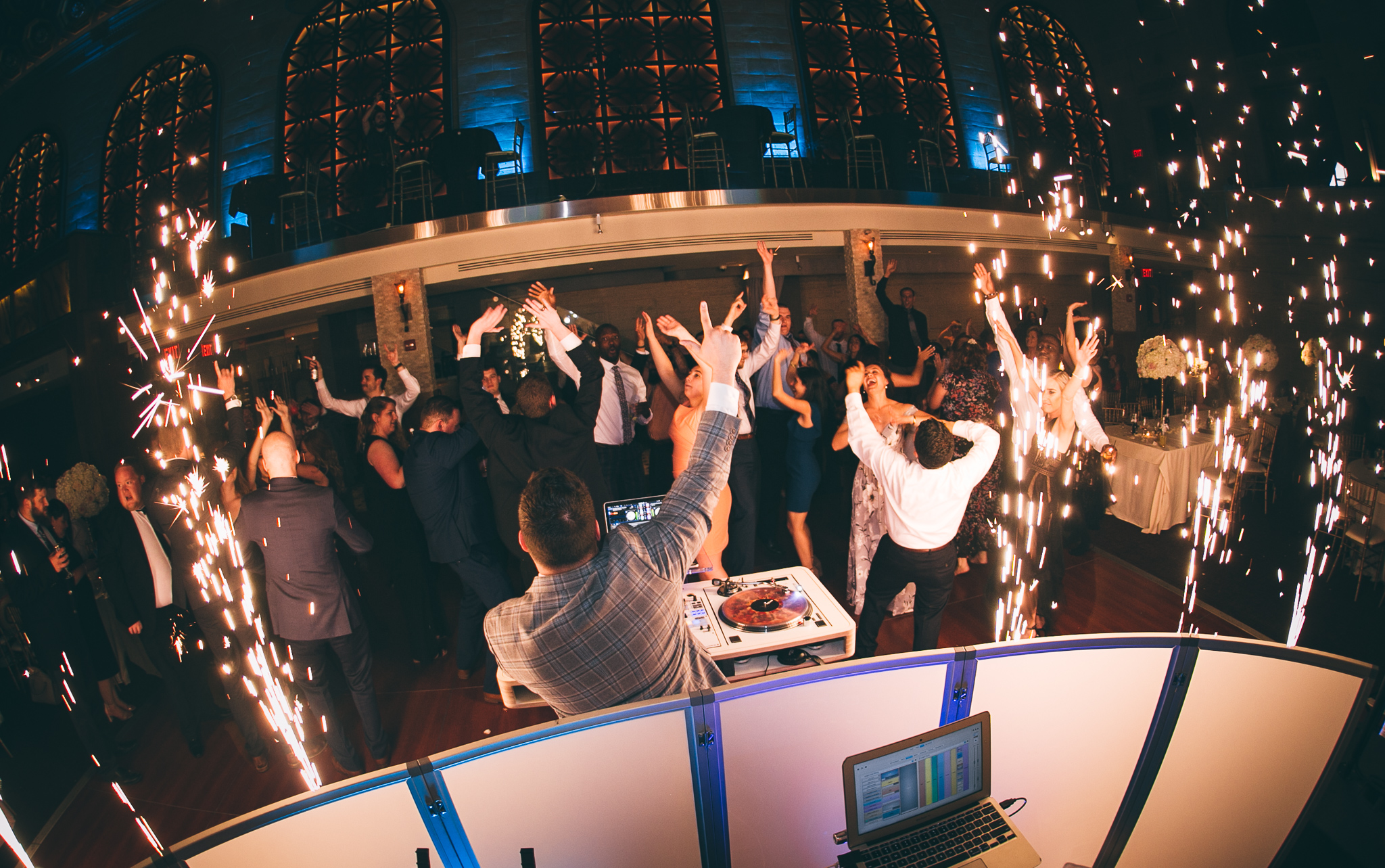 Packed wedding dance floor framed by sparklers
